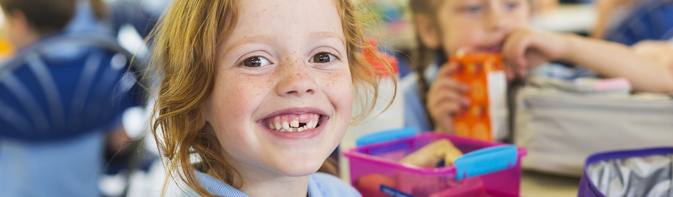 Girl smiling with her lunch box