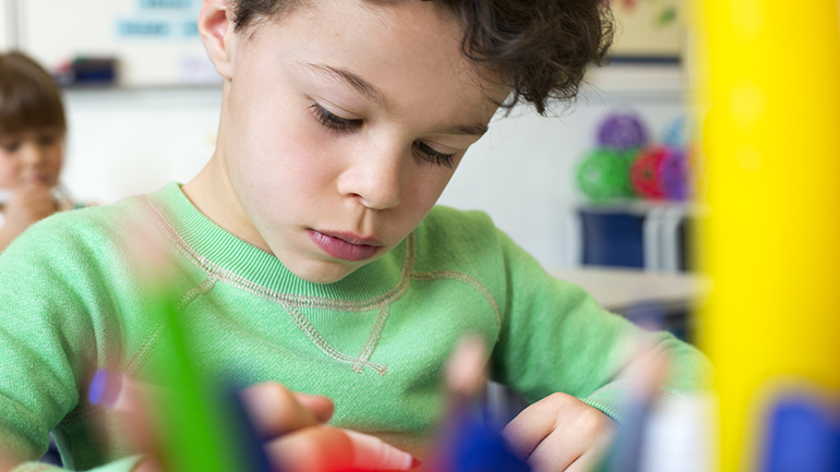 Child writing on desk