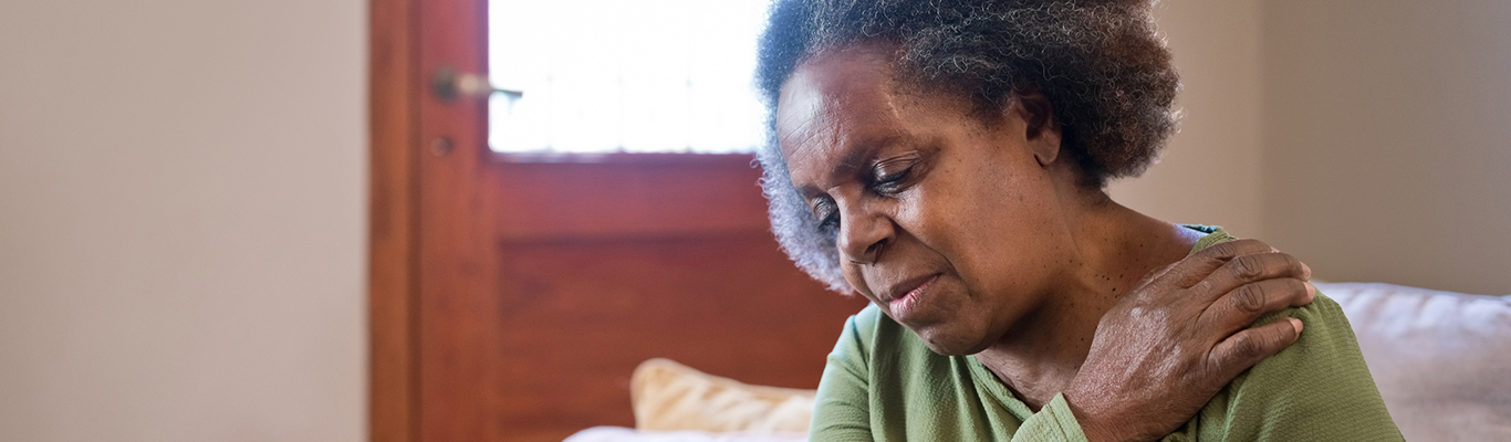 Image of mature woman holding shoulder in pain