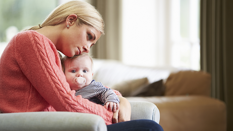 Sad mother holding baby