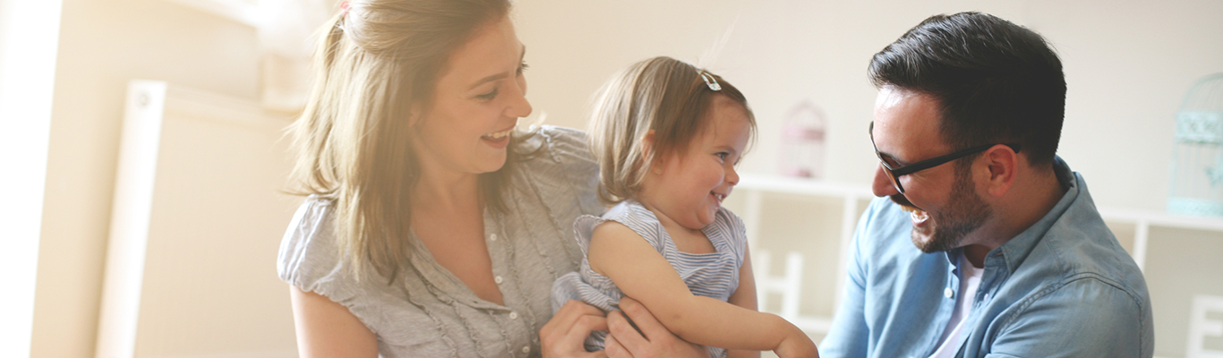 Mother, father and young daughter in living room