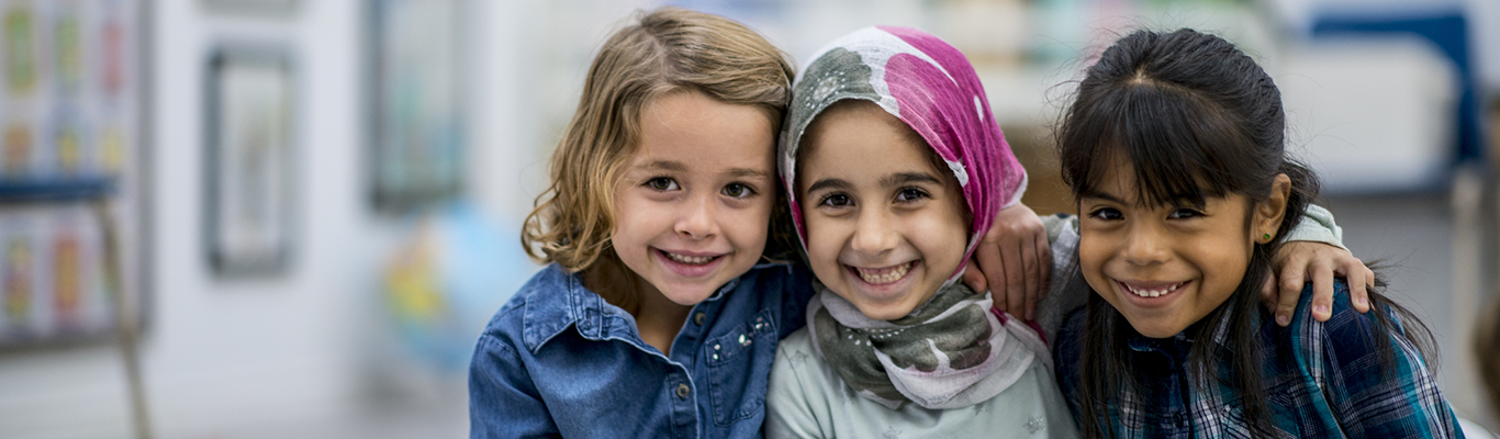 Three young girl friends hugging