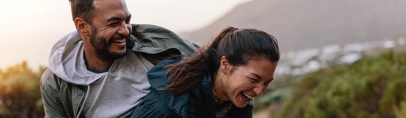 Portrait of happy young couple walking in the countryside and having fun. 