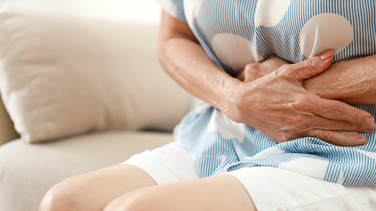 Midsection of a person having painful stomachache and holding their stomache