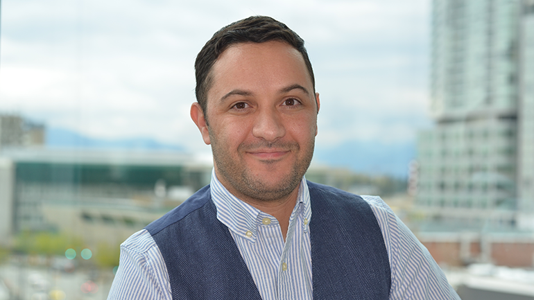 Photo of Bassam Chahira standing in front of a window.