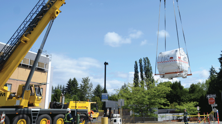 MRI being carefully hoisted off the truck