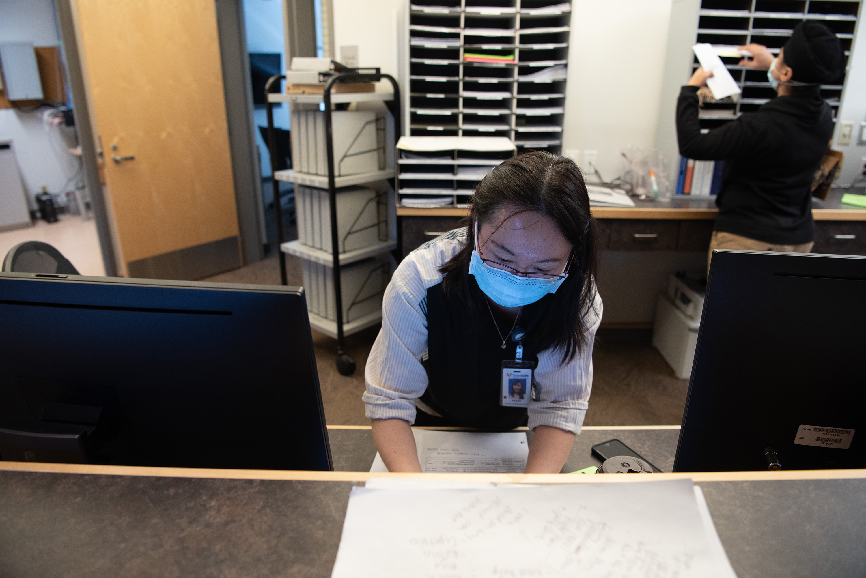 Fraser Health staff member at the reception desk preparing for the opening of Irene Thomas Hospice