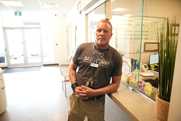 Curtis Carter leaning on desk inside building