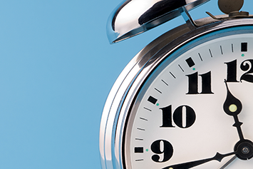 Analog alarm clock depicting 11:42.