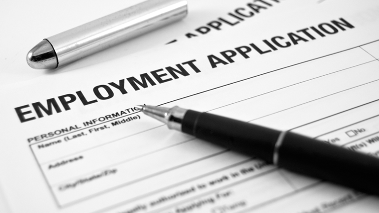 A pen on top of an employment application form