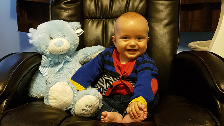 Baby sitting with a stuffed toy