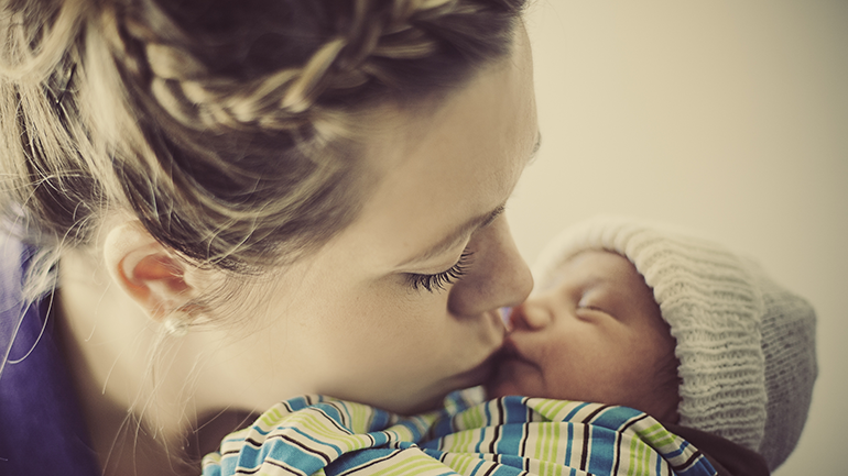 Mother kissing her baby