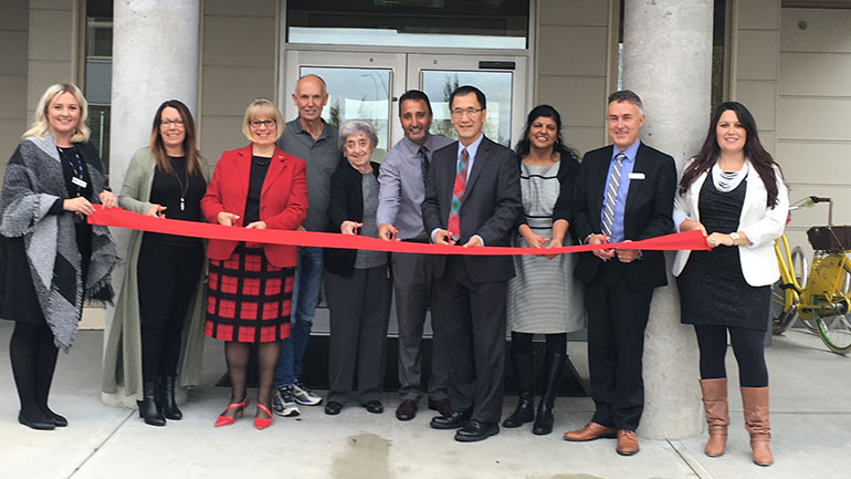 People cutting the ribbon in front of the newly opened Nicola Lodge