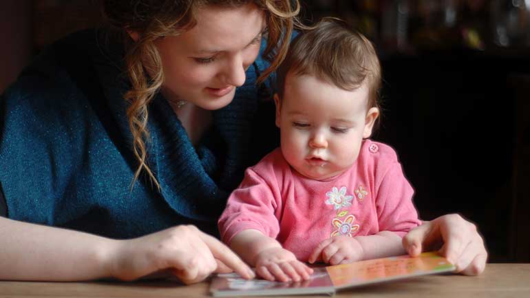 Mother teaching her daughter how to read