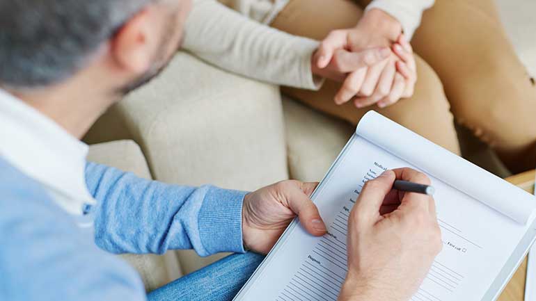 Health care provider with client taking notes