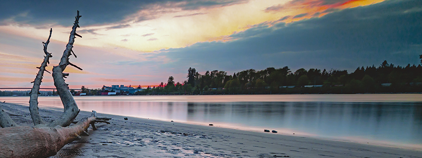 Langley at Derby Reach overlooking the Fraser River from a sandy beach at sunset