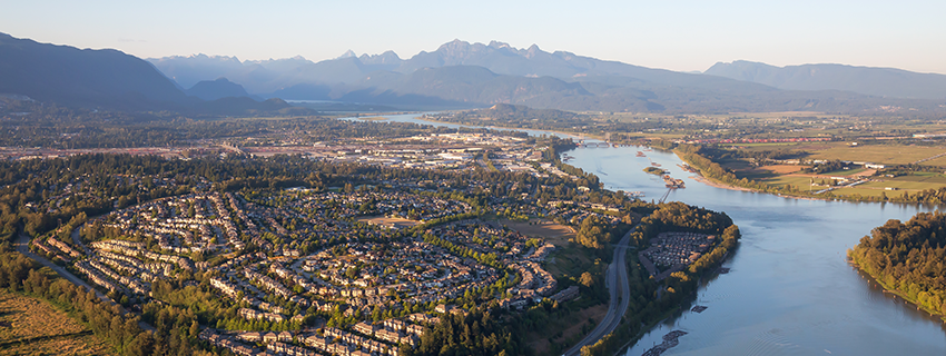 Port Coquitlam aerial view looking north towards the mountains with a foreground view of community streets and houses near the Fraser River