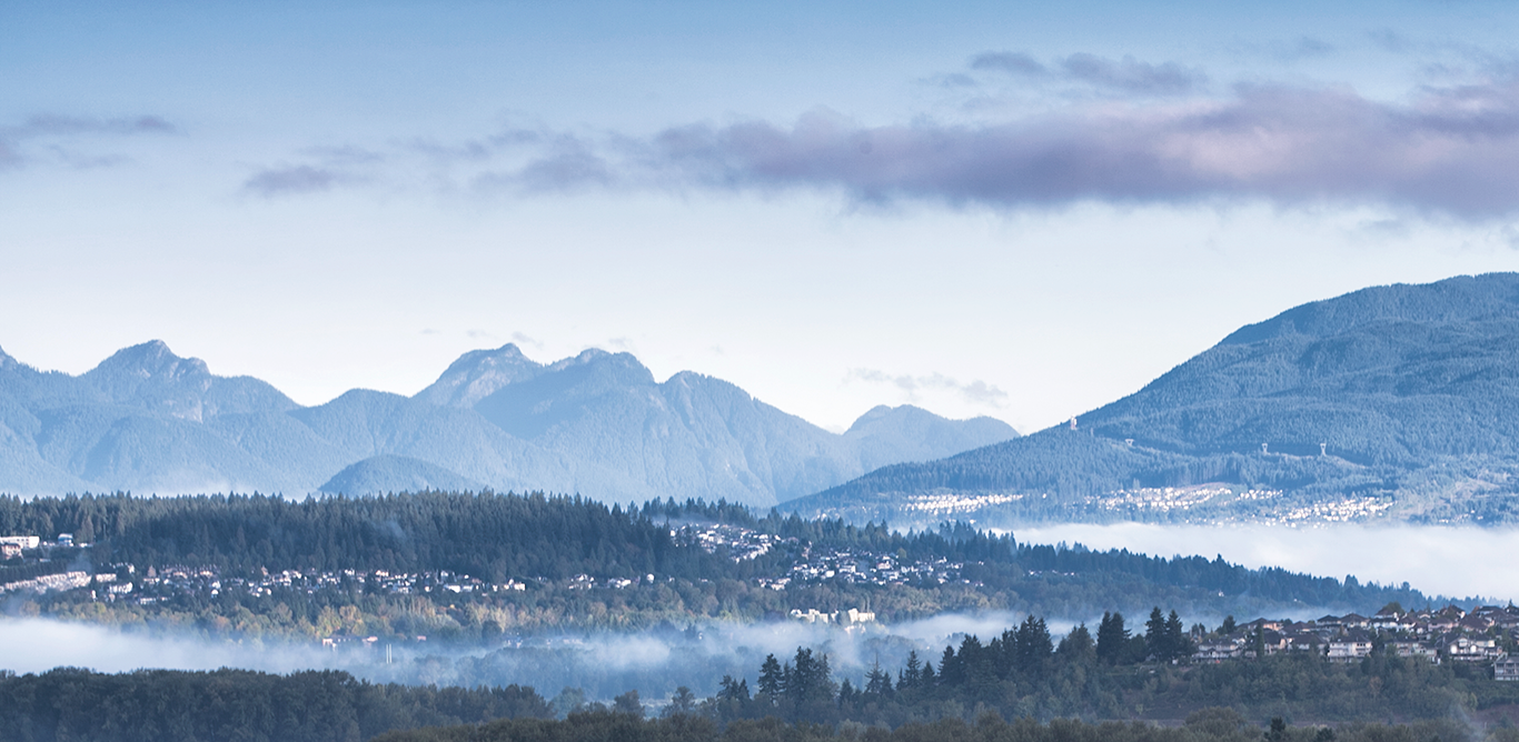 Aerial view of Port Coquitlam looking north towards the mountains with low laying fog in the valley