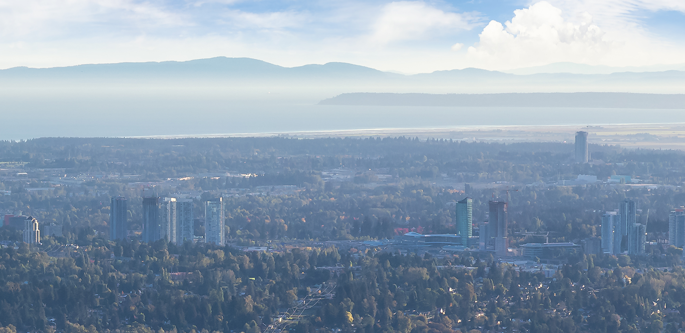 Skyline view looking southward towards Surrey BC, with the Cascade Mountains south of the city
