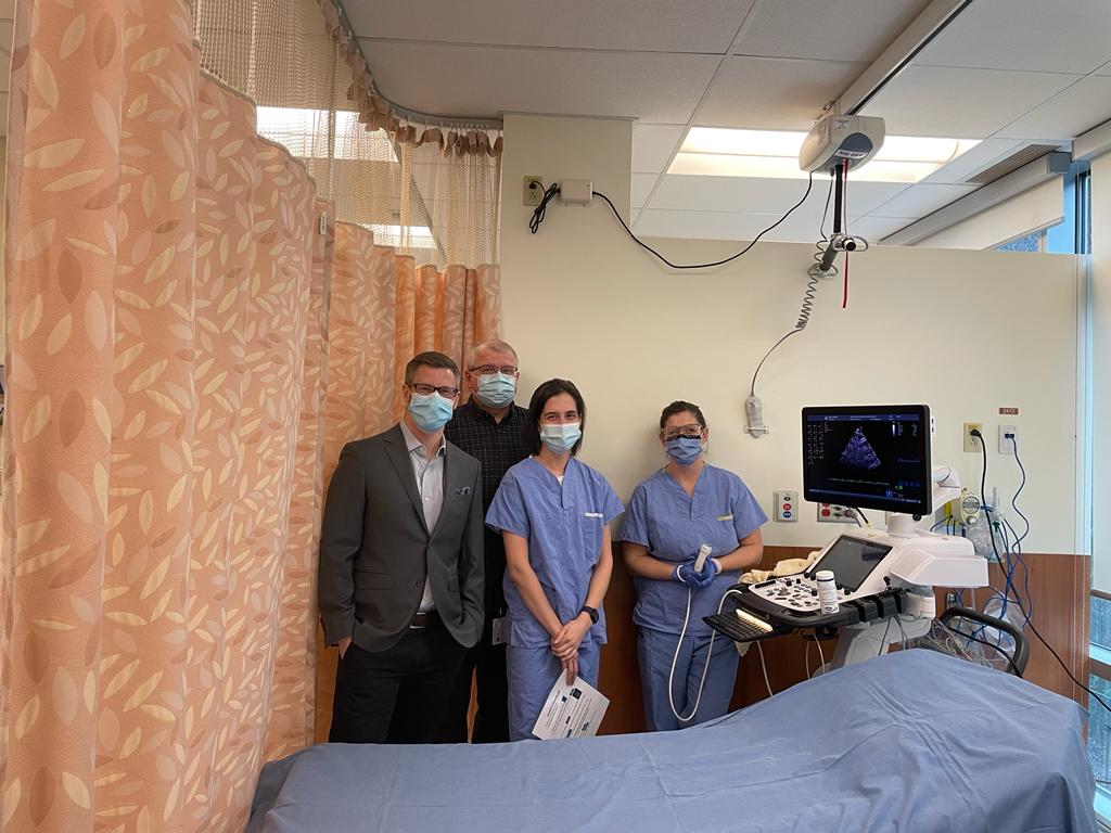 Three health care professionals standing in stress echo testing room