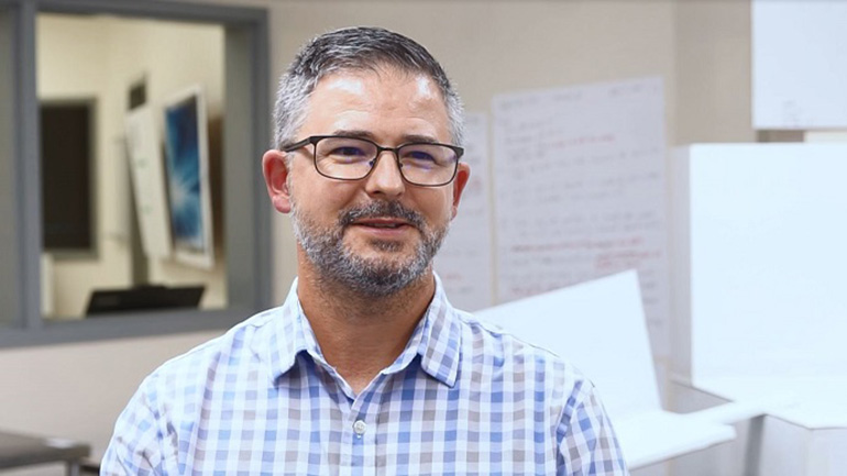 Man posing for photo in office.