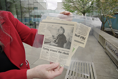 Sheila Early holding newspaper clippings