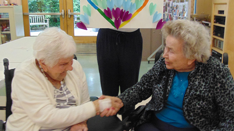 Rainbow heart artwork and two people holding hands