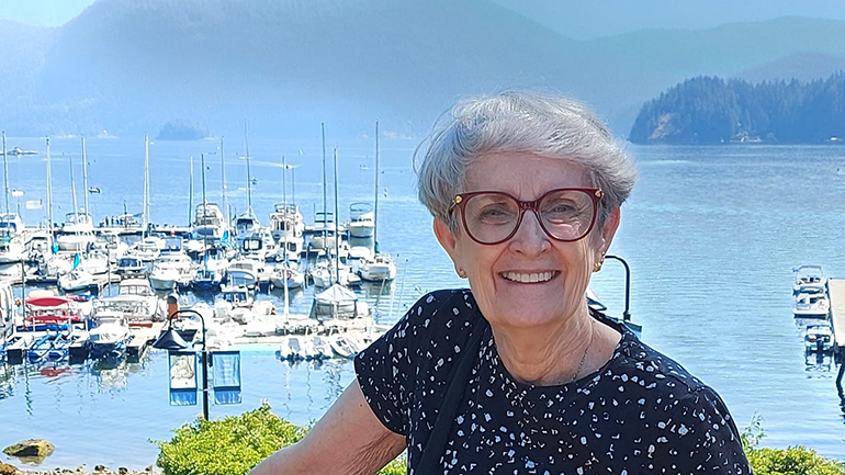 Woman standing in front of scenic landscape.