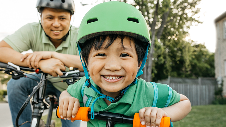 Young Asian boy with dad on bike