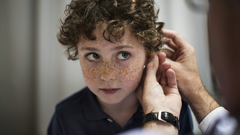 Boy getting fitted for hearing aid