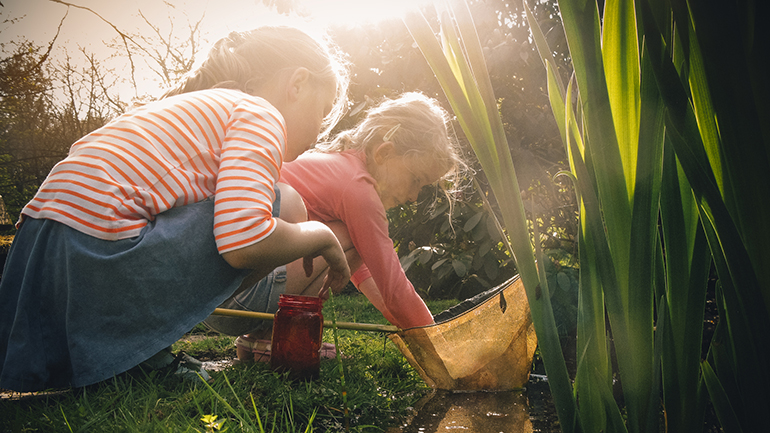 Two girls playing by the stream