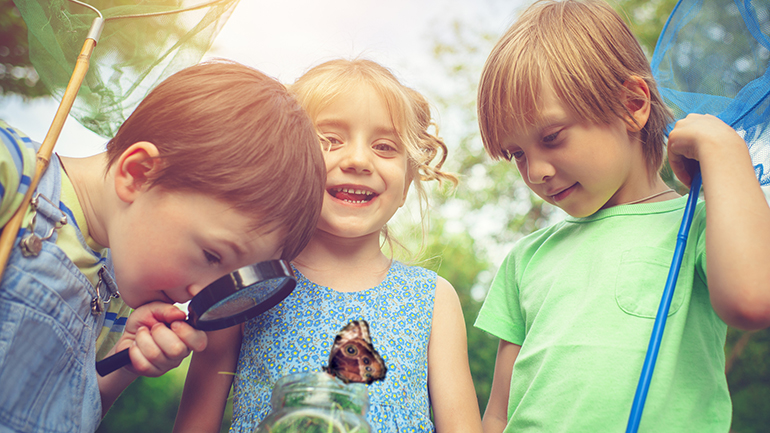Little boys and girl looking at a butterfly