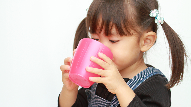 Young Japanese girl drinking from cup