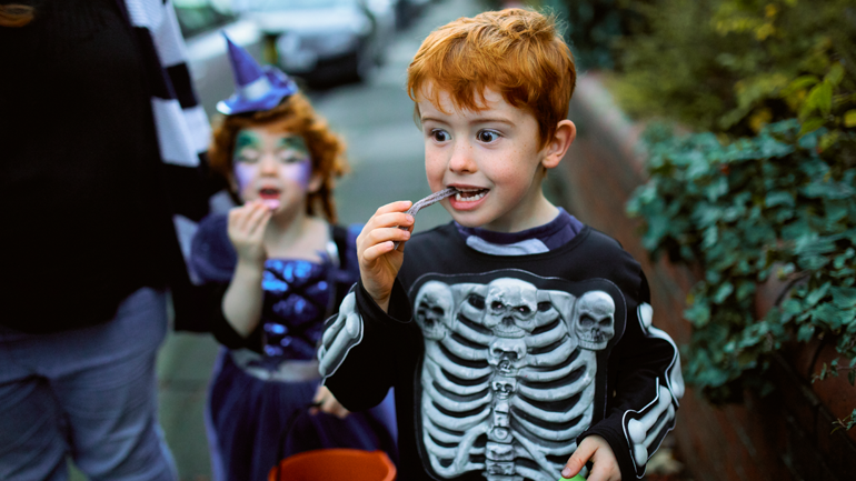 Child eating candy while trick or treating