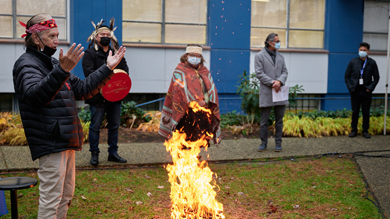 (Left) Arthur Pangilinan, manager, Volunteer Resources, Burnaby Hospital and (right) Sameer Vohra, manager, Operating Room, Burnaby Hospital placing small pouches of tobacco on top of the fire.