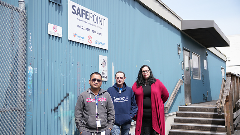 Three people standing in front of SafePoint building