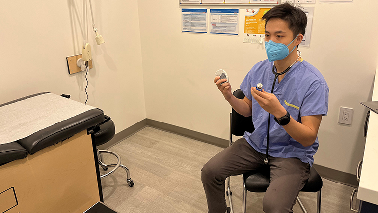 Doctor sitting in patient room holding asthma inhaler