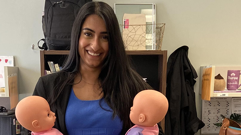 Simran Sanghera, registered nurse, holding two baby dolls