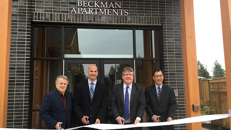 Cutting ribbon in front of Beckman Apartments