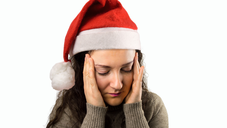 Woman wearing a Santa Hat is having a headache