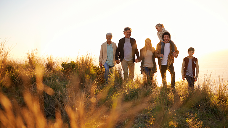 Family walking on a grassy hill