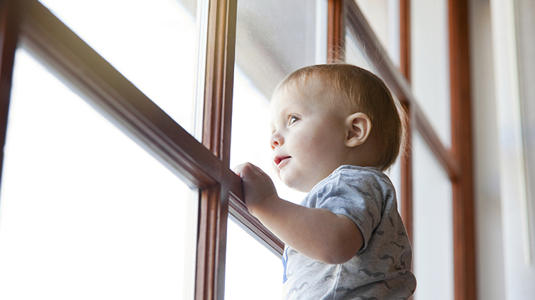 Child Standing and looking out the window