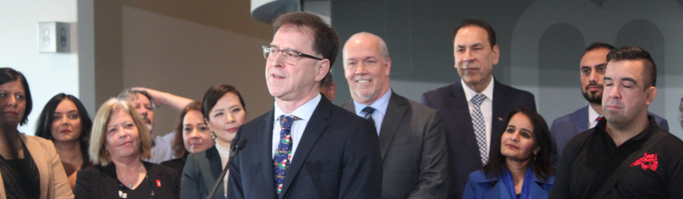 BC Minister of Health, Adrian Dix, speaking at a podium about the new hospital for Surrey