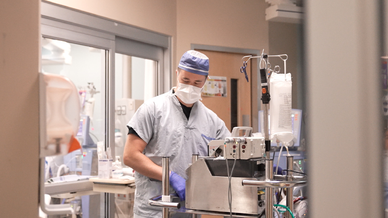 Man in scrubs with equipment.