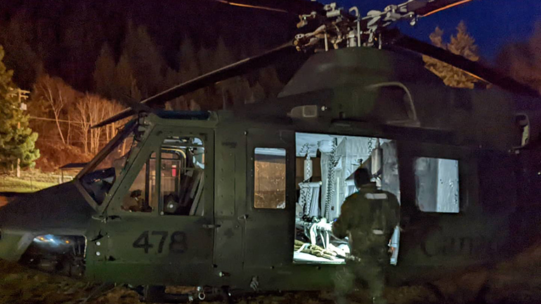 Man standing in front of helicopter.